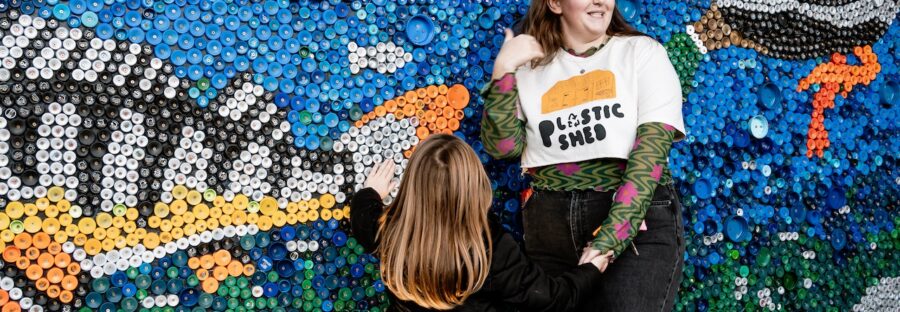 Artist (Caitlin) in front of the mural in Stockport